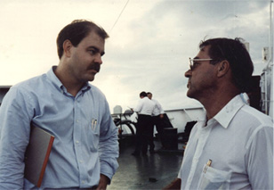 Men having a conversation on a ship's deck.